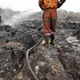 A firefighter from the local disaster management agency tries to extinguish a peatland fire in a palm oil plantation in Pelalawan, Riau province on the Indonesian island of Sumatra, September 26, 2015.